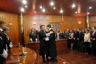 El nuevo presidente de la AP y su padrino se saludan durante el acto de toma de posesión